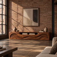 Low wood tv stand with a rippling carved front and an open top slot in an industrial loft living room with exposed brick