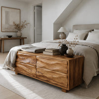 Low bench with four wavy grain front panels on short block feet in a Scandinavian bedroom with white walls