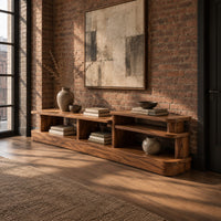 Low stepped open shelf console table with a raised section at one end in an industrial loft entryway with exposed brick
