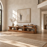 Low stepped open shelf console table with a raised section at one end in a bright open plan entryway