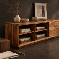 Corner detail of low storage bench with four open cubbies and a closed wood panel beside wood, brass and linen samples