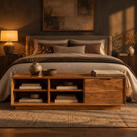 Low storage bench with four open cubbies and a closed wood panel in a dark bedroom at golden hour