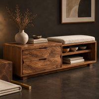 Corner detail of low bench with two drawers, an open shelf cubby and a seat pad beside wood, brass and linen samples