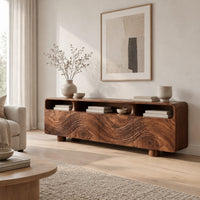 Low wood tv stand with a carved wave front and open top compartments in a Scandinavian living room with white walls