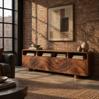 Low wood tv stand with a carved wave front and open top compartments in an industrial loft living room with exposed brick