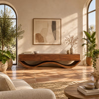 Low tv stand with three front panels on a wave shaped base in a bright living room with arched windows and plants