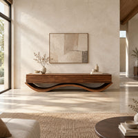 Low tv stand with three front panels on a wave shaped base in a bright open plan living room