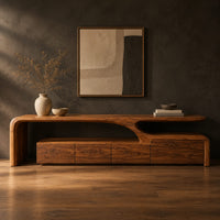 Low tv stand with a sweeping wave top and a four panel front in a dark studio against a charcoal plaster wall