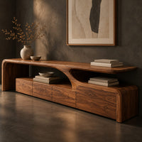 Corner detail of low tv stand with a sweeping wave top and a four panel front beside wood, brass and linen samples
