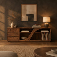 Low tv stand with three drawers and a swooping divider beside vertical slots in a dark living room at golden hour