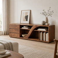 Low tv stand with three drawers and a swooping divider beside vertical slots in a Scandinavian living room with white walls