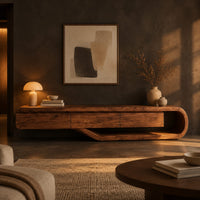 Low tv stand with a three panel front and a sweeping curved loop base in a dark living room at golden hour