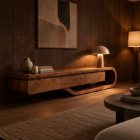 Low tv stand with a three panel front and a sweeping curved loop base in an evening living room with walnut wall paneling