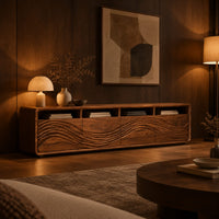 Low tv stand with four open cubbies above wave carved front panels in an evening living room with walnut wall paneling