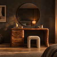 Makeup vanity desk with four wave carved drawers and a single slab leg in a dark bedroom at golden hour