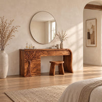 Makeup vanity with a carved tree pedestal and a sweeping slab leg in a bright open plan bedroom