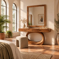 Makeup vanity with a wide top and an open oval loop base in a bright bedroom with arched windows and plants