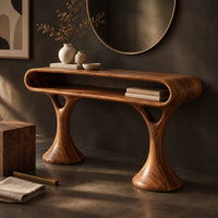 Corner detail of makeup vanity with a pill shaped open shelf top and flared pedestal legs beside wood, brass and linen samples