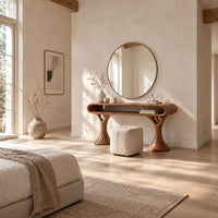 Makeup vanity with a pill shaped open shelf top and flared pedestal legs in a bright open plan bedroom