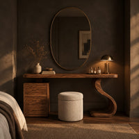 Makeup vanity with an s curve pedestal and a three drawer cabinet in a dark bedroom at golden hour