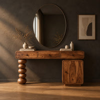 Makeup vanity with three drawers a stacked bead leg and a side cabinet in a dark studio against a charcoal plaster wall