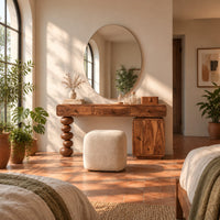Makeup vanity with three drawers a stacked bead leg and a side cabinet in a bright bedroom with arched windows and plants