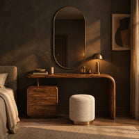 Makeup vanity with a waterfall end and a three drawer cabinet in a dark bedroom at golden hour