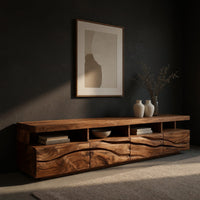 Media cabinet with open cubbies above carved wave drawers, three-quarter view showing the grain