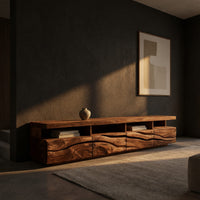 Media cabinet with open cubbies above carved wave drawers in a living room at golden hour