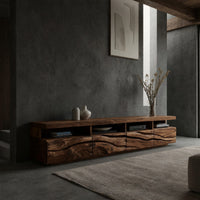 Media cabinet with open cubbies above carved wave drawers in a concrete and timber loft