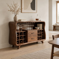 Mid century bar cabinet with a curved frame, square cubbies and two drawers in a Scandinavian dining room with white walls