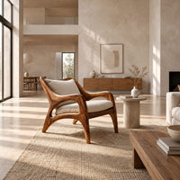 Wooden armchair with sweeping sculpted arms and splayed legs in a bright open plan living room