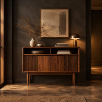 Mid century console table with fluted front and tapered legs in a dark entryway at golden hour