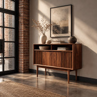 Mid century console table with fluted front and tapered legs in an industrial loft entryway with exposed brick