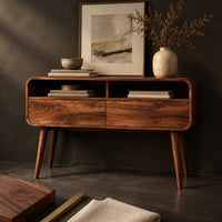 Corner detail of mid century wooden console table with open compartments above two front panels beside wood, brass and linen samples