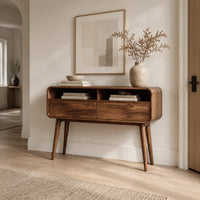 Mid century wooden console table with open compartments above two front panels in a Scandinavian entryway with white walls