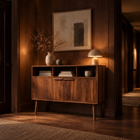 Mid century console table with three open cubbies and two doors on tapered legs in an evening entryway with walnut wall paneling