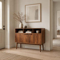 Mid century console table with three open cubbies and two doors on tapered legs in a Scandinavian entryway with white walls