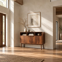 Mid century console table with three open cubbies and two doors on tapered legs in a bright open plan entryway