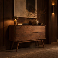 Low cabinet style console table with three wood panels on splayed legs in an evening entryway with walnut wall paneling