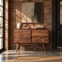 Low cabinet style console table with three wood panels on splayed legs in an industrial loft entryway with exposed brick