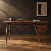Mid century desk with tapered legs and a wedge shaped two drawer box in a dark studio against a charcoal plaster wall