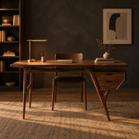 Mid century desk with tapered legs and a wedge shaped two drawer box in a dark home office at golden hour
