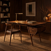 Mid century desk with tapered legs and a wedge shaped two drawer box in an evening home office with walnut wall paneling