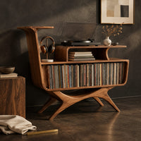 Corner detail of mid century record console with an open bin, a raised tier and splayed legs beside wood, brass and linen samples