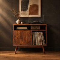 Mid century record player stand with one flat door and tapered legs in a dark studio against a charcoal plaster wall