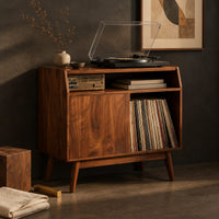 Corner detail of mid century record player stand with one flat door and tapered legs beside wood, brass and linen samples