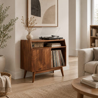Mid century record player stand with one flat door and tapered legs in a Scandinavian living room with white walls