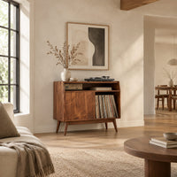 Mid century record player stand with one flat door and tapered legs in a bright open plan living room