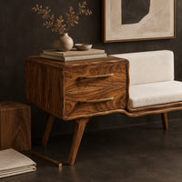 Corner detail of mid century bench with a two drawer cabinet end and a cushioned seat beside wood, brass and linen samples